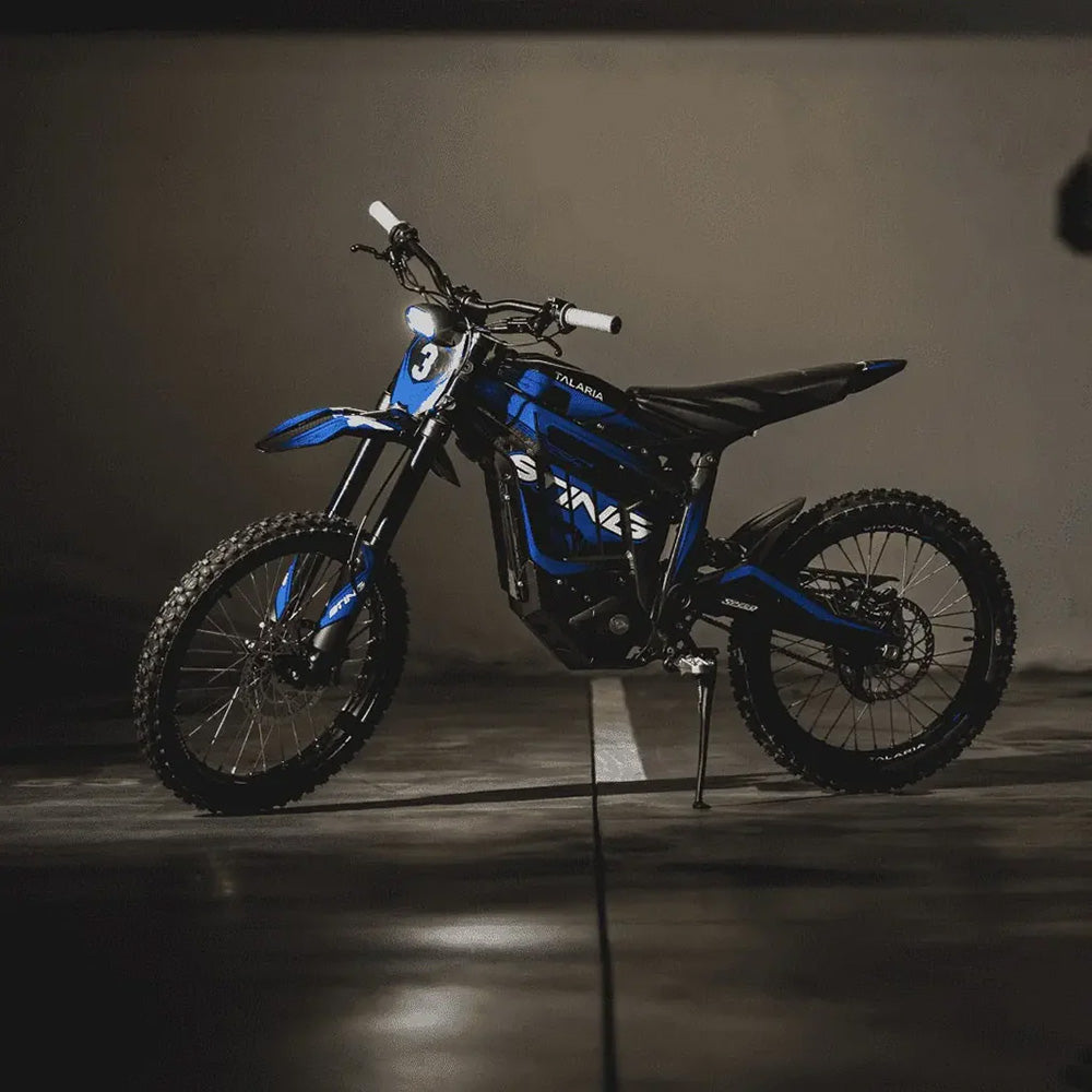 Side view of Talaria Sting R MX4 on a stand, highlighting its electric drivetrain and rugged build, ideal for all-terrain riding