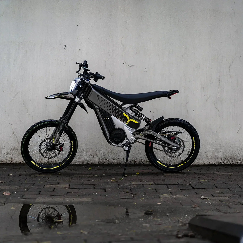 Side profile of Talaria XXX electric dirt bike, showcasing sleek design, off-road tires, and powerful motor for extreme trail performance